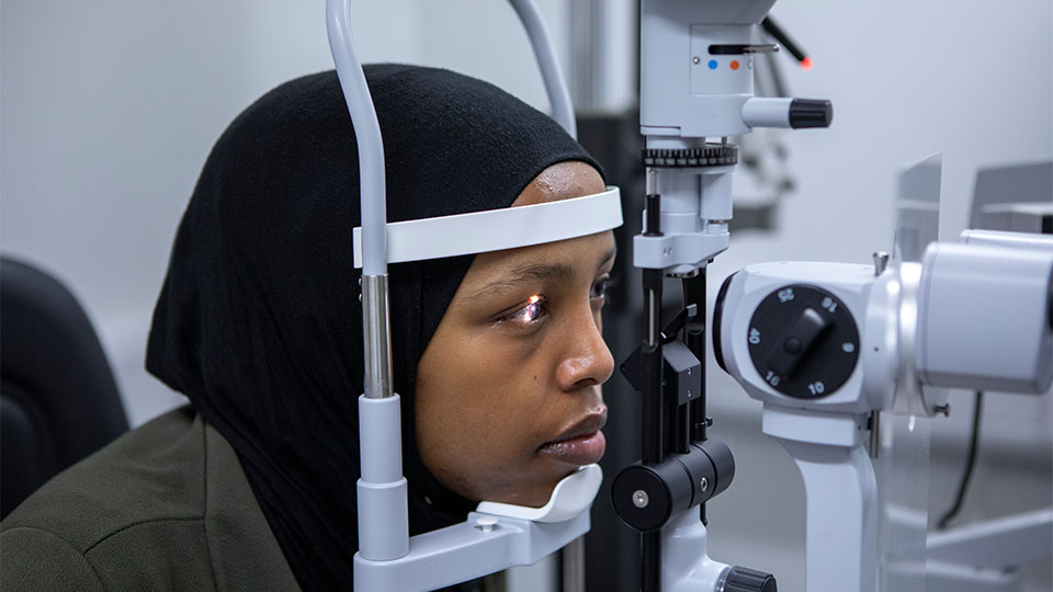 Patient having her eyes examined with an optometer
