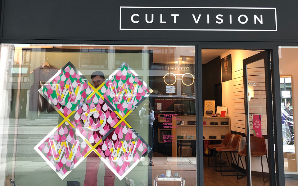 The front of the Cult Vision practice in London with the large ‘WOW’ artwork painted on the window. Archie is behind the glass painting on the reverse